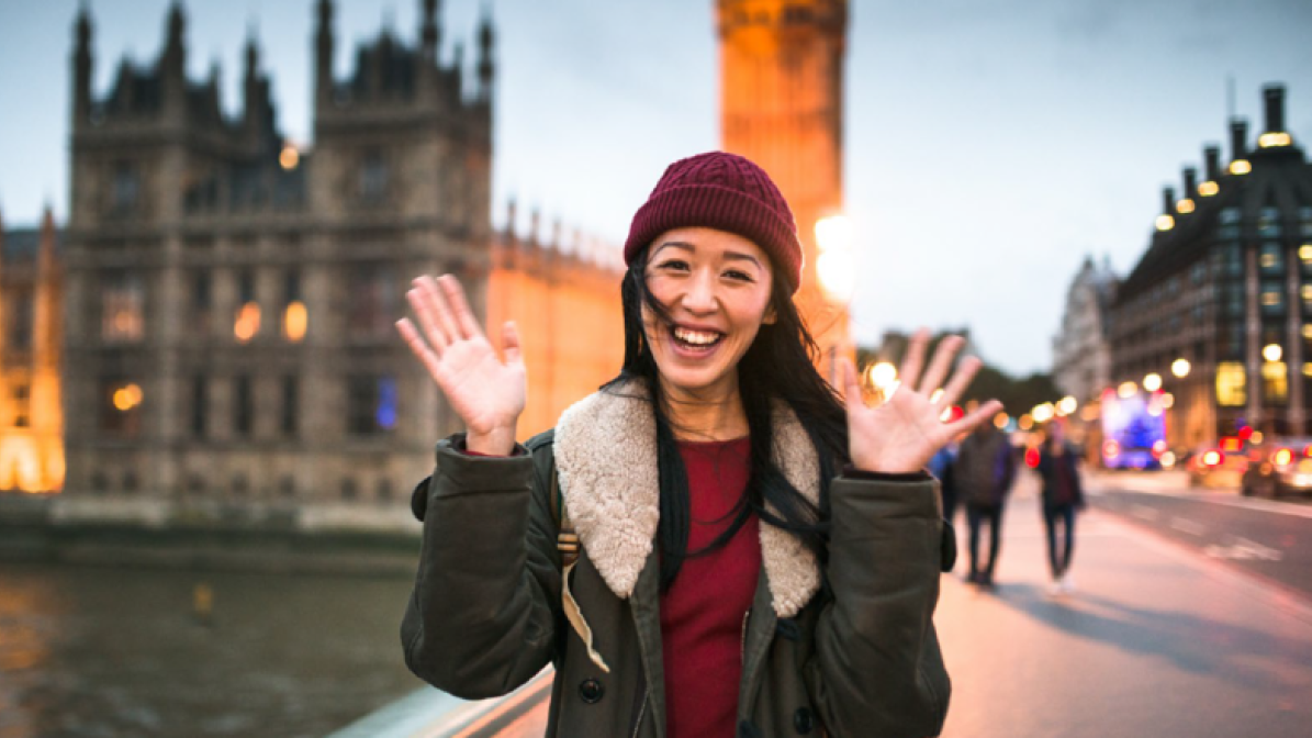 Chinese student walking across a bridge in London 