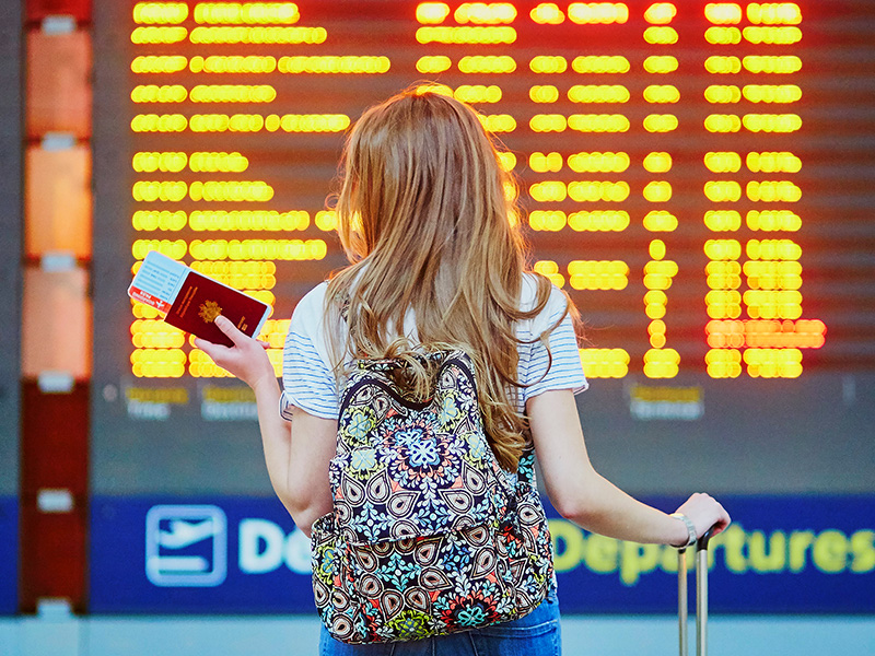 Young woman holding a passport and ticket at an airport