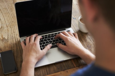 Close-up of person's hand using a laptop