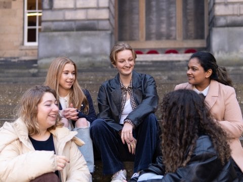 Students sitting on steps on campus chatting